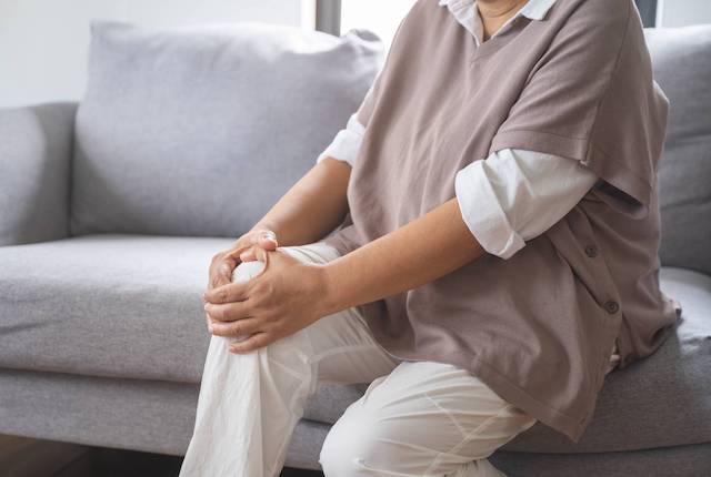 膝をおさえる女性